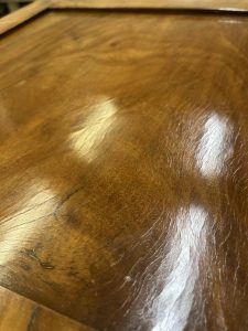 Nettoyage et repose des bronzes dorés (chapiteaux, entrées de serrures) typiques du style Empire pour redonner de l'éclat au meuble.