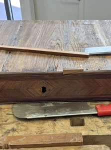 Greffe de massif sur un tiroir d'un secrétaire Louis XV en Bois de violette restauré à l'Atelier Roba à Paris